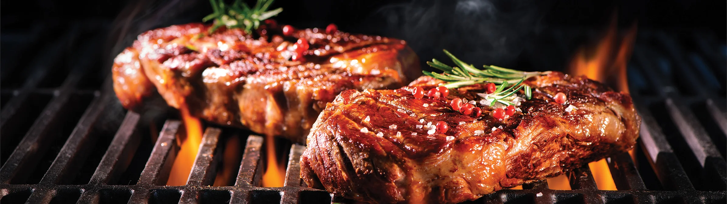 Beef steaks on the grill with flames