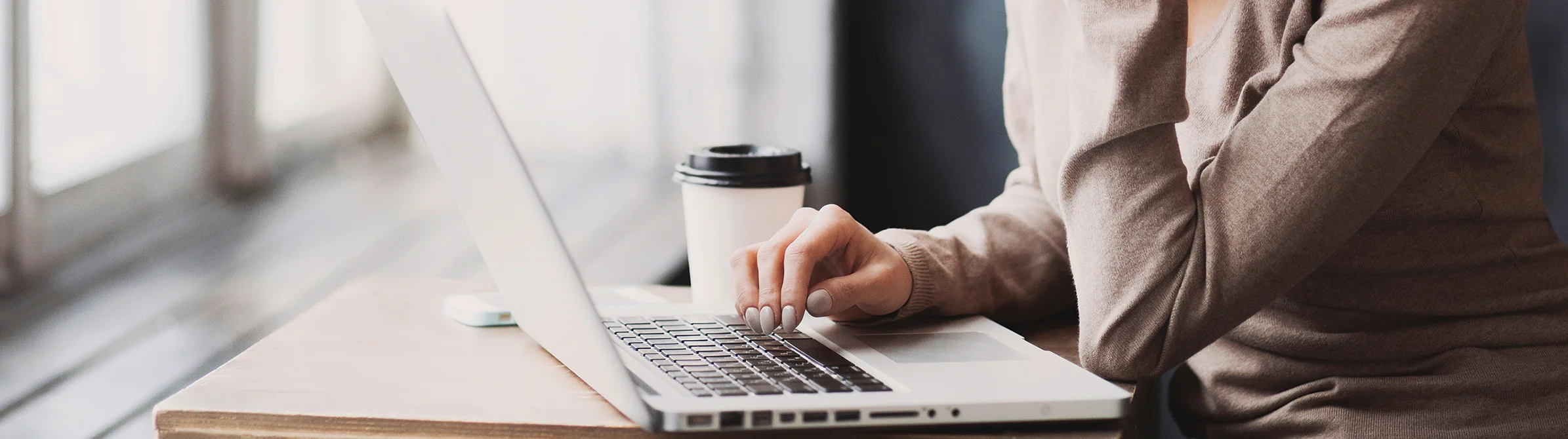 Person's hands using a laptop keyboard